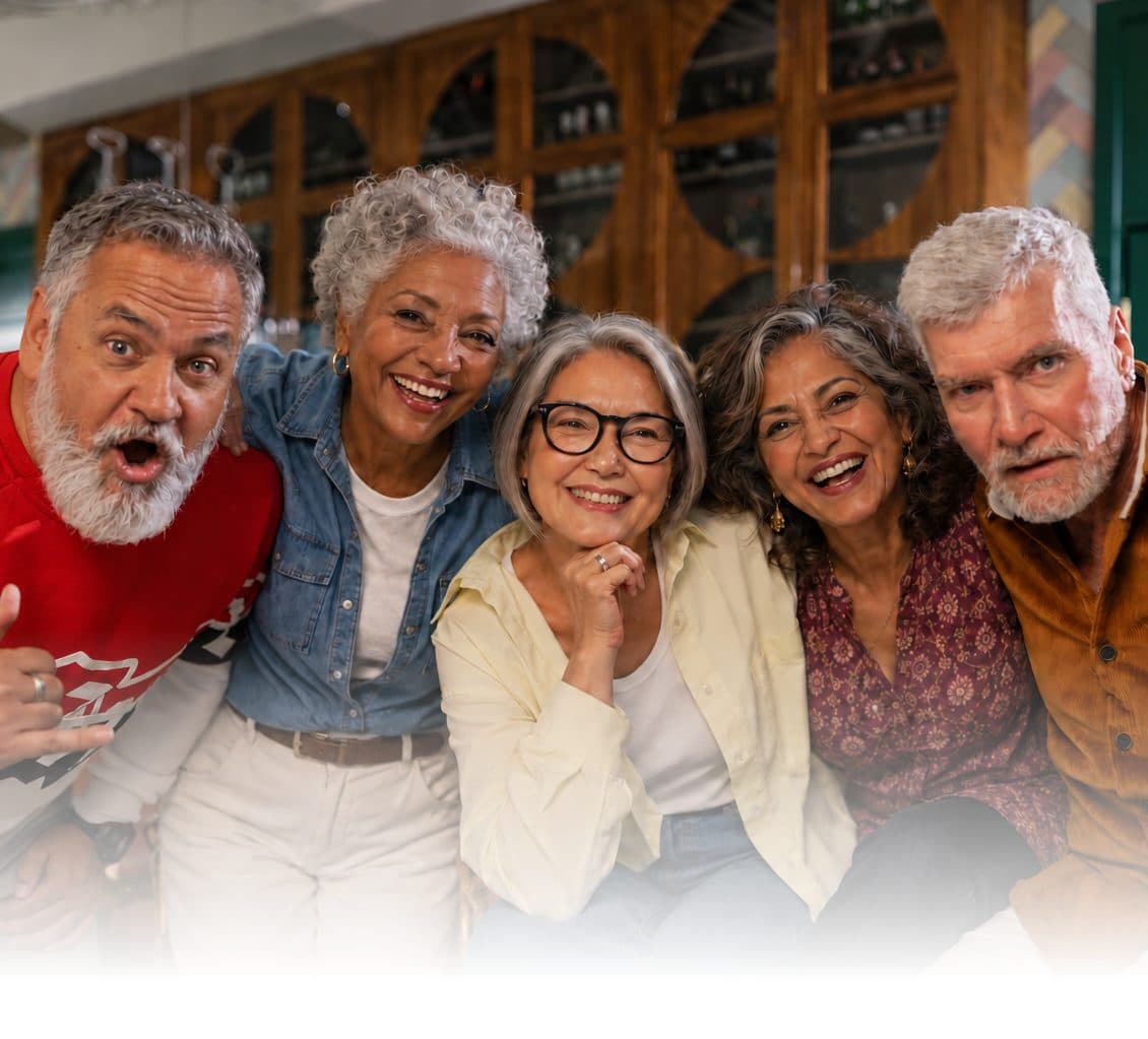 Five friends in their sixties laughing together
